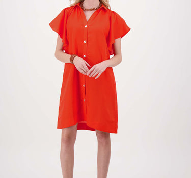 Model draagt een linnen fladdermouw jurk met zakken in coral van Zusss.
