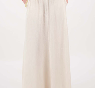 Crinkle skirt with lining in cream by Zusss; model is wearing a cream top and brown sandals