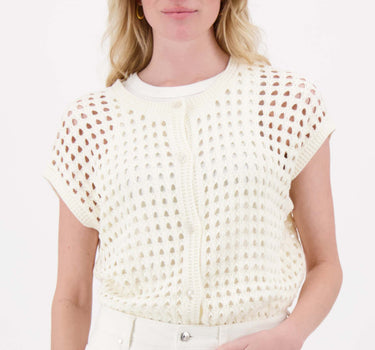Model draagt off white ajour vestje mouwloos van Zusss, met opengewerkt dessin en ribboord.