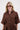 Piloten zonnebril met hoeken en koker gold gedragen door model in bruine blouse met ceintuur van Zusss