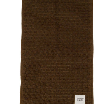 This "This Moment Is Gold Brown" guest towel by Zusss is a dark brown cotton towel with a geometric texture.
