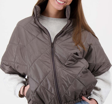 Doorgestikte bodywarmer green taupe gedragen door model, grijze trui en jeans van Zusss