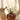 A small "Terra" terracotta heart-shaped vase by Zusss in a charming living room still life featuring a flower and a wooden candleholder.