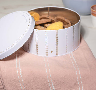 Model draagt white / ochre koekblik streep hartje love is all around van Zusss, stijlvol in de keuken.
koekblik streep hartje love is all around | white / ochre van Zusss, ronde tin met streepdetail.
koekblik streep hartje love is all around | white / ochre van Zusss, sfeervolle tafelsetting met koekjes.