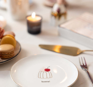 gebaksbordje taartje hoera | wit van Zusss, op tafel met macarons en kaarslicht.