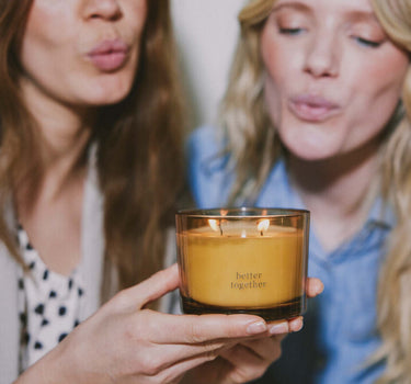 geurkaars glas met deksel better together | transparent / gold van Zusss, twee vrouwen tonen amberkleurige kaars.